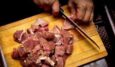 person cutting up meat