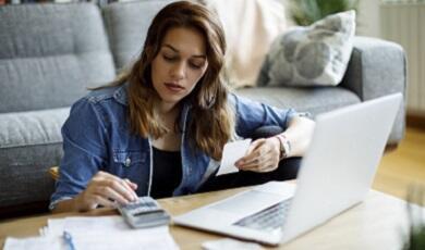 woman working on laptop with paperwork