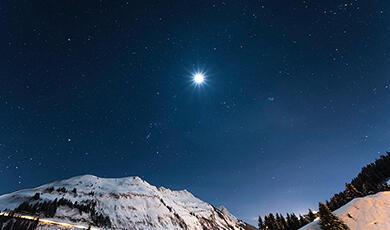 Bright star in the night sky over mountain