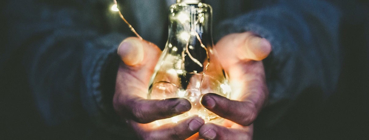 hands holding light bulb