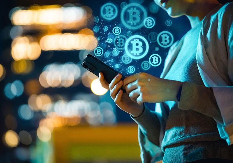 a woman on a smartphone with animations of bitcoin logos