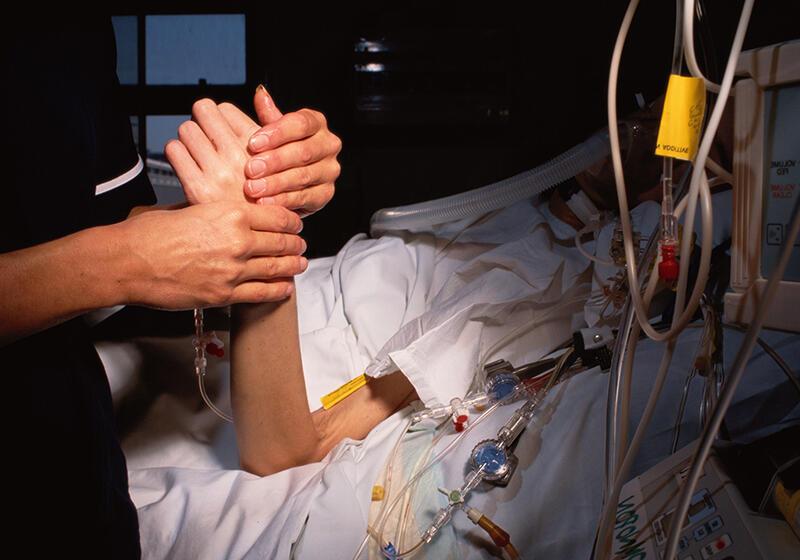 a nurse holding the hand of a patient in hospital