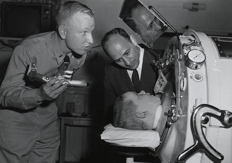 a polio-affected child being placed in an iron lung