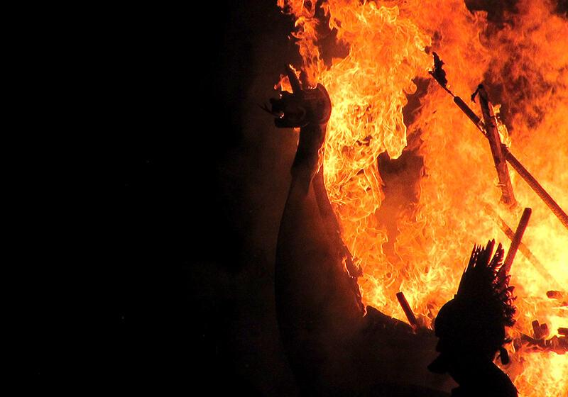 Viking longboat with dragon head on fire