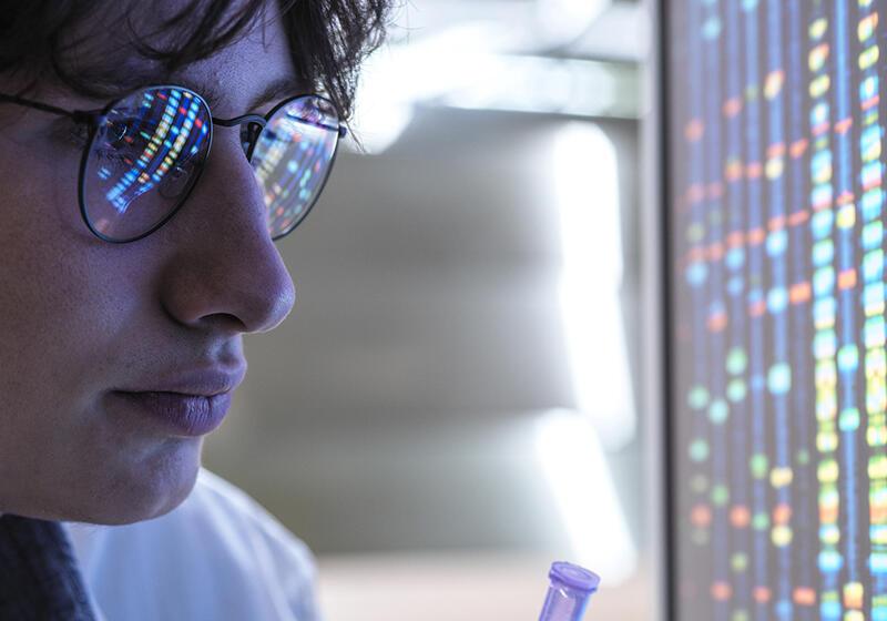 a photograph of a man looking at a screen with graphics displayed