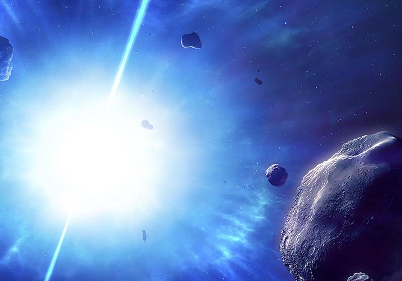 a bright light in space with asteroids in the foreground