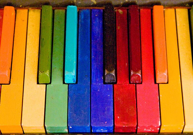 piano keys painted in the colours of the rainbow