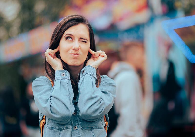 a woman sticking her fingers in her ears