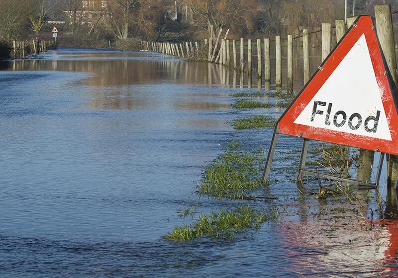 a sign reading Flood next to a body of water