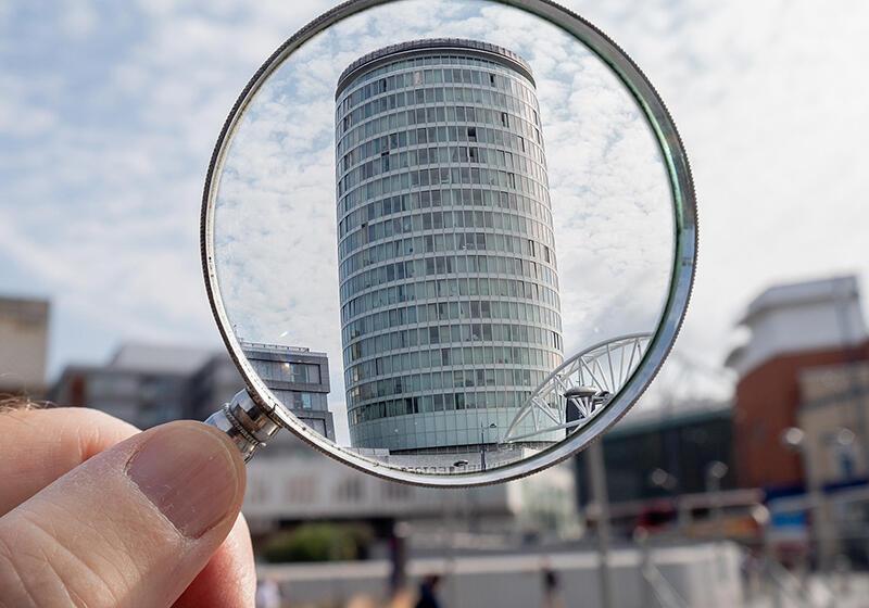 a magnifying glass with the Rotunda in Birmingham, UK