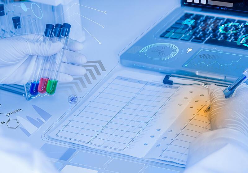three vials of liquid next to a laptop and a clipboard