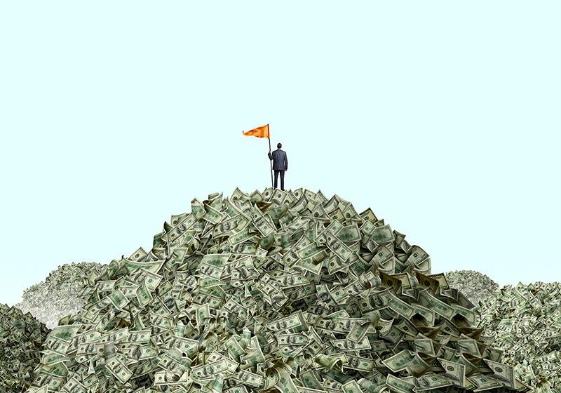 Toy man with flag on top of pile of money