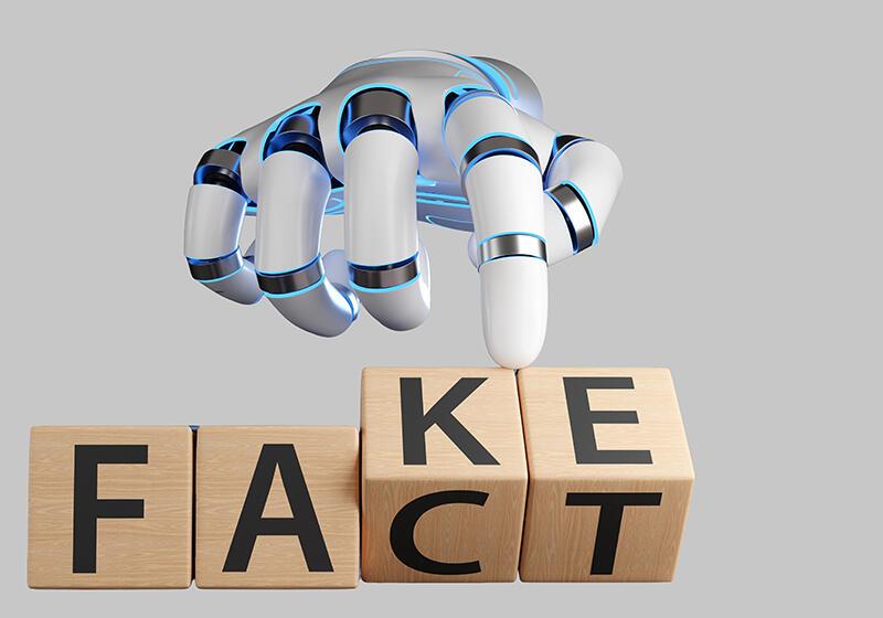 Robot hand moving block letters reading 'FACT' to 'FAKE'