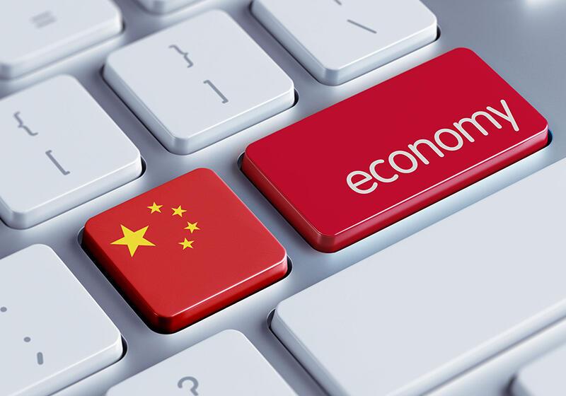 A close-up of a computer keyboard with a red key labeled "economy" and a key with the flag of China