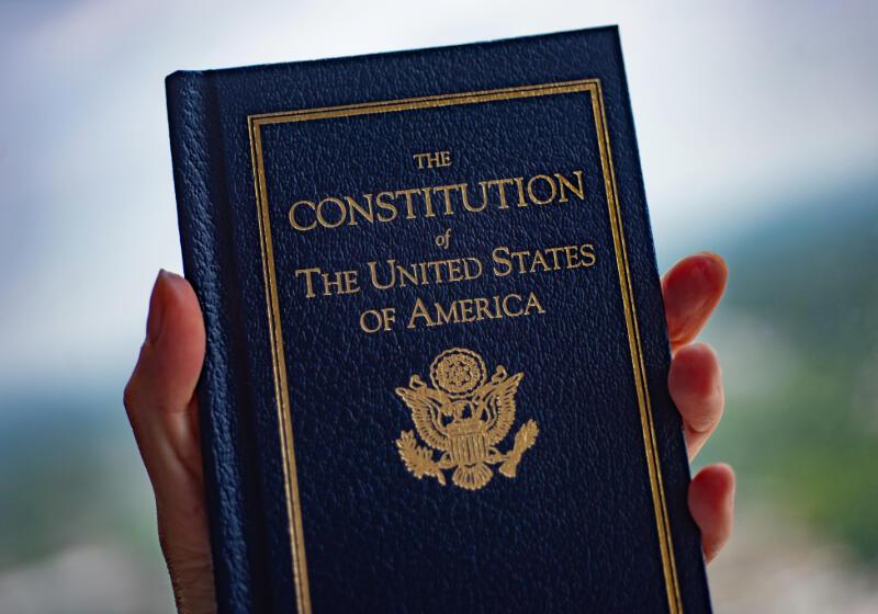 Hand holding up book of US Consitution