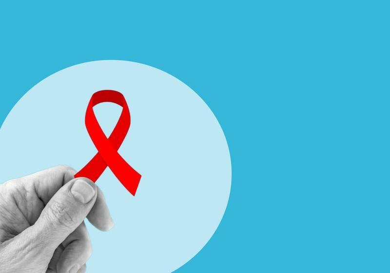 A close-up graphic features a black-and-white hand holding a vibrant red awareness ribbon against a light blue circular backdrop, all set on a solid bright blue background