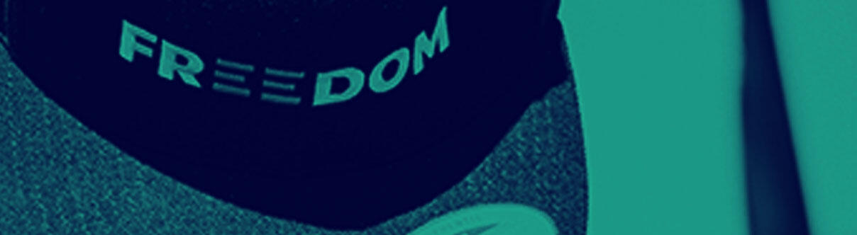 back of protester with cap saying 'Freedom' on