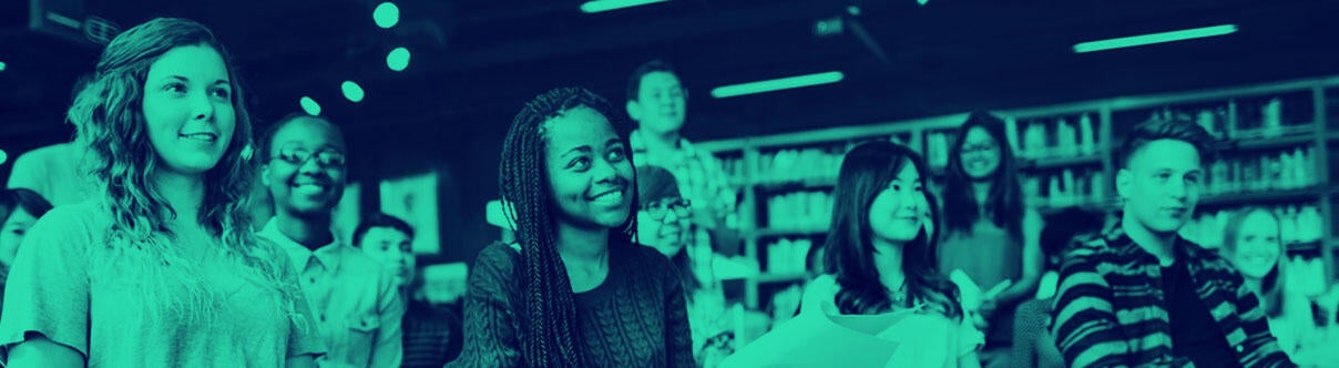 Young people sitting listening to a speaker in a library setting