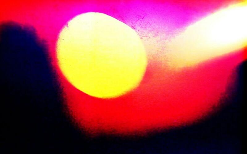 giant yellow sun-like orb on red backgroun
