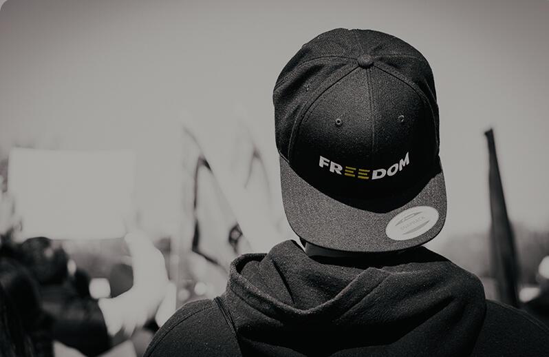 back of protester with cap saying 'Freedom' on