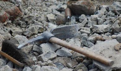 A hammer lying on a rocky or gravelly surface