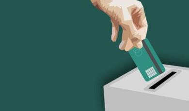 Hand dropping credit card into ballot box