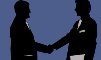Silhouettes of businessmen shaking hands