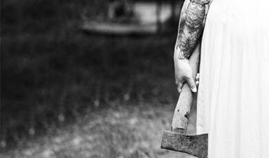 bottom half of woman in white dress holding axe