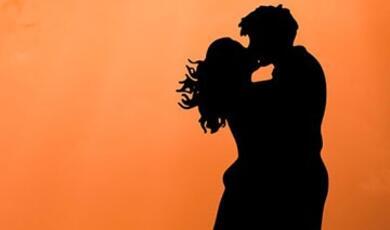 couple kiss against orange background