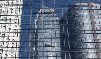 skyscrapers reflected in windows of neighboruing building