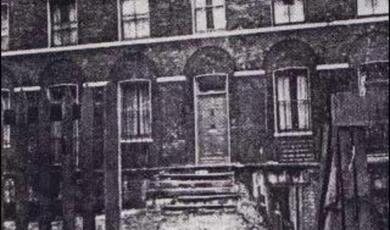 Black and white photograph outside terraced house