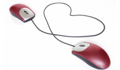 two computer mice, joined by their cables which are in the shape of a heart