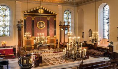 Path towards St Paul's front door lit with strings of bulbs at night