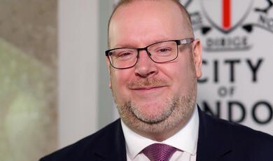 green and blue image of the inside of a watch, cogs and mechanism