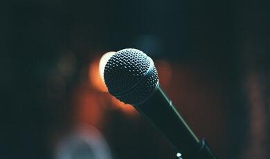 schools competition banner image of grasshopper with microphone