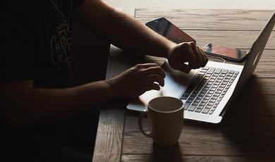 close up of hands typing on laptop