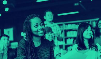 Young people sitting listening to a speaker in a library setting