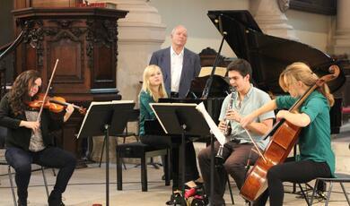 Photo of Professor Christopher Hogwood standing with musicians