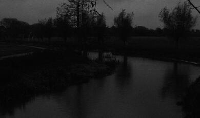 grainy black and white image of a river
