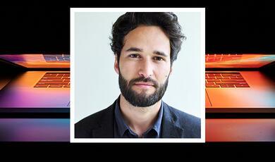 Professor Daniel Susskind on backgroun showing a laptop computer