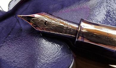 Antique pen lying on ink-stained paper