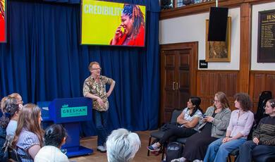 Finalists sit in a circle listening to a speaker at our pre-competition training in our medieval hall