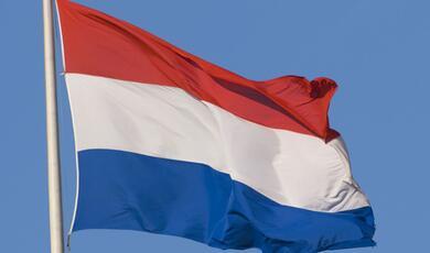 the flag of The Netherlands flying on a flagpole