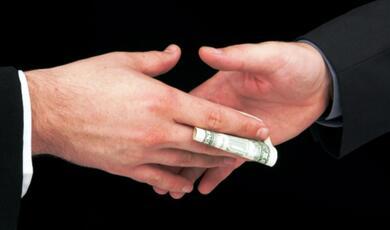 two hands exchanging money surreptitiously