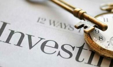 zoomed in photography of a key, a pocket watch and the word 'Investment' on a document