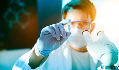 a scientist inspecting a vial of liquid