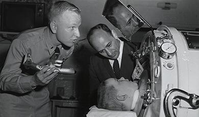 a polio-affected child being placed in an iron lung