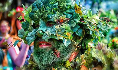 a man's face wearing a mask made of plants
