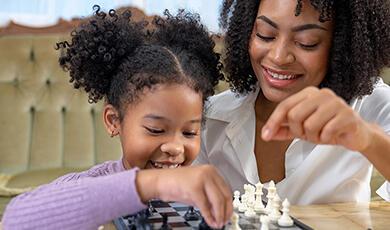 Black woman and child playing chess