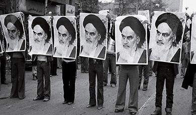 Line of Iranians holding big posters of Ayatollah Khomeini